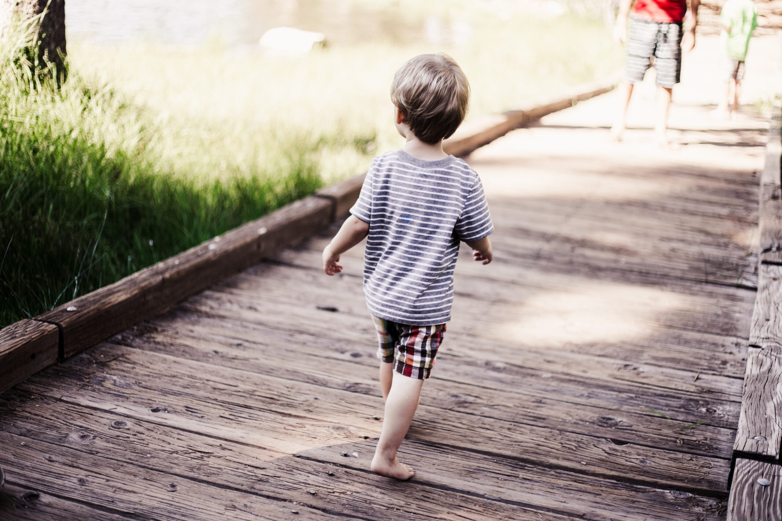 toddler walking across bridge